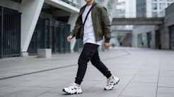 Man wearing a streetwear jacket with a hoodie and sweatpants